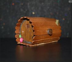 a small wooden box with a door and flowers on it