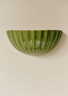 a green bowl sitting on top of a white table