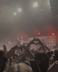 a group of people standing on top of a stage with their hands in the air