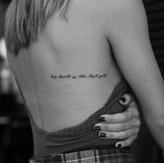 the back of a woman's shoulder with an inscription on it