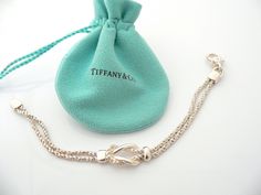 Do you know which items made Tiffany a world renowned company? You just stumbled upon one of them! Offered for sale is a wonderful vintage Tiffany and Co. Sterling Silver Double Rope Love Knot bracelet - in a rare longer length - 7.75 inches. The piece is made from solid and substantial Tiffany silver, yet has a very delicate and feminine feel to it. The bracelet is very unique - hard to find and come by, so grab it while you have the chance! It is very pretty worn on its own, but would also wor Luxury Chain Bracelet With Sterling Silver Clasp As Gift, Elegant Silver Bracelet With Hallmarks, Elegant Wedding Chain Bracelet With Lobster Clasp, Engraved Chain Bracelet For Formal Occasions, White Gold Jewelry With Clasp For Gift, Timeless Bracelet With Lobster Clasp For Gift, Timeless Bracelets With Lobster Clasp For Gift, Elegant Chain Bracelet With Clasp As Gift, Vintage Sterling Silver Clasp Chain Bracelet Gift