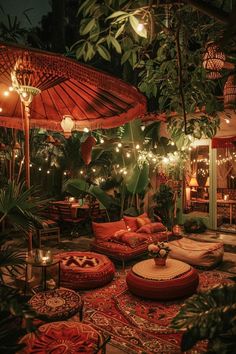 an outdoor living area with lots of plants and lights on the ceiling, including umbrellas