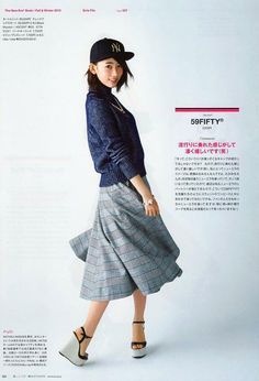 a woman in a skirt and hat is posing for a magazine cover shot with her hand on her hip