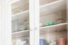 a glass cabinet filled with lots of different colored items on top of each other's shelves