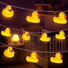 rubber ducks are strung on a string in the dark room, and lit up with yellow leds