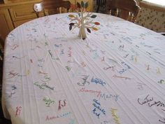 a white table cloth with writing on it and a tree made out of letters sitting on top of it