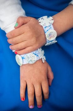 a woman's hand with two bracelets on her wrist and one holding the other