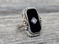 Vintage 14K Black Onyx Diamond & Sea Pearls Ring. Beautiful black onyx with a sparkling diamond at the center set on antique design white gold setting with sea pearls and rose gold flowers with yellow gold leaves. It is a gorgeous unique piece to treasure!  Please notice this is an antique ring with original sea pearls that I can see some wears on the pearls and lose of luster.  Size 4 1/2 Weights 5.7g Onyx measures 18.5mm x 10mm Center diamond 2.5mm  Marked: 14K This is an estate item that was Antique Black Jewelry For Wedding, Antique Black Wedding Jewelry, Black Rose Cut Diamond Jewelry For Evening, Evening Black Rose Cut Diamond Jewelry, Wedding Jewelry With Black Enamel And Onyx, Antique Onyx Jewelry For Anniversary, White Gold Jewelry With Black Enamel For Wedding, White Gold Wedding Jewelry With Black Enamel, Black Enamel Fine Jewelry For Wedding