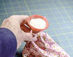 a person holding a small bowl with food in it