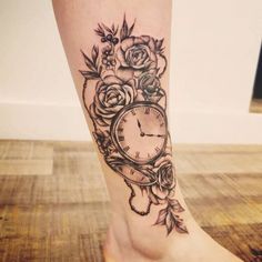 a woman's foot with a clock and roses tattoo on the side of her leg