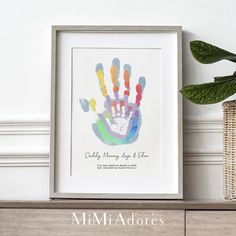 a colorful hand print with the words daddy, mommy, and me on it next to a plant