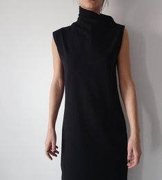 "A sheath sleeveless dress with elevated asymmetric collar is both unique and trendy, suitable to wear on various occasions. It is tailored in straight, but flattering shape, so it fits all types of figures. Details: Care: turn the garment inside out for better washing results, machine wash cold, tumble dry low, warm iron if needed Fabric: a medium weight cotton elastic jersey Size: You may choose one of 7 standard sizes (XS, S, M, L, XL, XXL & 3XL); Please check our size charts below to cho Chic Black Asymmetrical Sleeveless Dress, Black Stretch Sleeveless Asymmetrical Dress, Black Sleeveless Stretch Asymmetrical Dress, Chic Sleeveless High Neck Dress For Work, Chic High Neck Sleeveless Dress For Work, Chic Black Sleeveless Asymmetrical Dress, Chic Asymmetrical Stretch Sleeveless Dress, Chic Asymmetrical Sleeveless Stretch Dress, Black Asymmetrical Sleeveless Fitted Dress