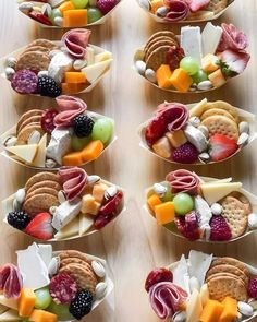 several small bowls filled with different types of cheese and crackers on top of a wooden table