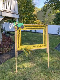 a yellow sign sitting on top of a lush green field