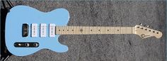 a blue electric guitar laying on the ground