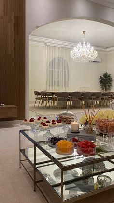 a glass table filled with lots of food on top of a white carpeted floor