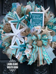 a starfish wreath on the front door with a sign that says welcome to the beach