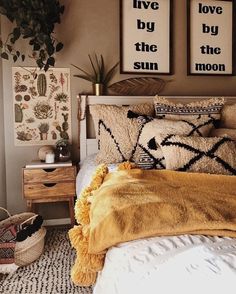 a bedroom with two pictures on the wall above the bed, and a yellow blanket