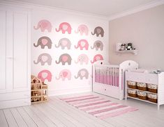 a baby's room with pink and gray elephants on the wall