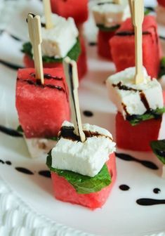 watermelon skewers with marshmallows and mint on a white plate