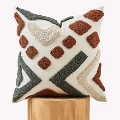 a white and brown pillow sitting on top of a wooden stand