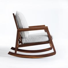 a wooden rocking chair with a white cushion