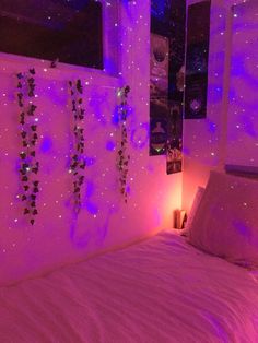 a bed with purple lights in a bedroom next to a window and mirror on the wall