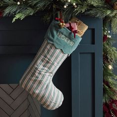 a christmas stocking hanging from the side of a fireplace