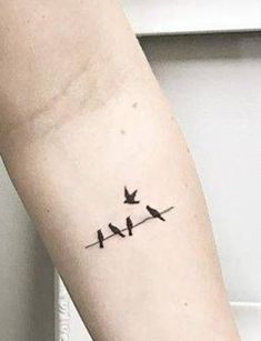 two birds on a wire tattoo on the arm