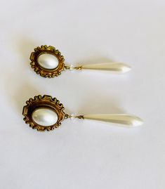 Lovely vintage costume jewelry post earrings with dramatic faux pearl drops and oval, bezel set faux oval cabochons with a clear crystal in gold toned setting. Great sparkle and movement in these elegant and dramatic Art Nouveau style earrings. Both earrings have some wear on the pearls as is expected with vintage - one oval has two tiny marks ... please see photos. Beautiful vintage drop earrings with free First Class domestic shipping! US sellers are not authorized to collect VAT/customs fees Vintage White Pearl Drop Earrings, Metal Teardrop Clip-on Earrings With Pearl Drop, Vintage Drop Earrings For Pierced Ears, Vintage Pearl Drop Earrings For Party, Vintage Teardrop Earrings For Formal Occasion, Vintage Teardrop Pearl Earrings For Pierced Ears, Vintage Oval Pearl Earrings For Formal Occasions, Vintage Cabochon Dangle Earrings, Vintage Oval Metal Earrings