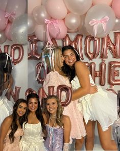 two girls are hugging each other in front of balloons