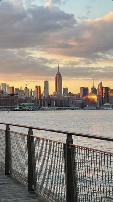 there is a view of the city skyline from across the water at sunset or dawn