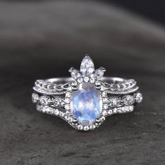 a white gold ring with an oval blue stone surrounded by diamonds