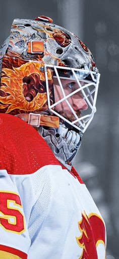 an ice hockey goalie's helmet with flames on it