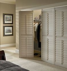 an open closet with white shutters on the doors