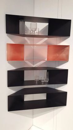 a wall mounted shelf with glass vases and other items on it's sides