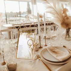 the table is set with place settings, candles and menus for an elegant dinner