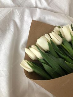 a bouquet of white tulips in a brown box