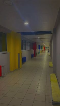 an empty hallway with yellow and red doors