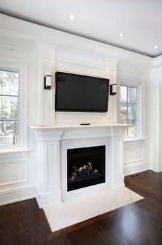 a fireplace with a flat screen tv mounted on it's mantle in a living room