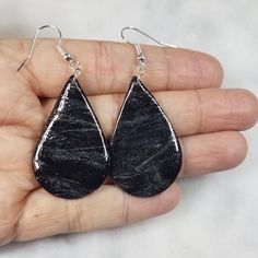 Handmade teardrop-shaped dangle earrings in a black and silver glazed pattern. Made from polymer clay. Mounted on hypoallergenic hooks. Smoke-free, pet-free home. Black Resin Dangle Jewelry, Black Resin Drop Earrings, Black Hypoallergenic Resin Earrings, Black Teardrop Earrings With Ear Wire For Gift, Black Teardrop Earrings As Gift, Silver Earrings Dangle, Black And Silver, Handmade Earrings, A Black