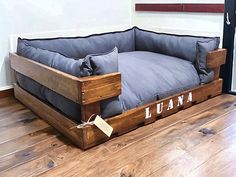 a dog bed made out of pallet wood with the word luana on it