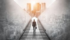 a man walking across a bridge with buildings in the background