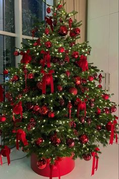 a christmas tree with red ornaments and bows