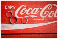 two pairs of scissors sitting on top of a coca - cola box