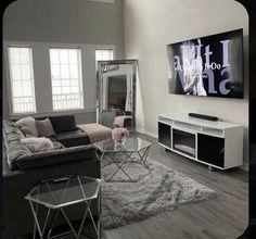 a living room filled with furniture and a flat screen tv mounted to the side of a wall