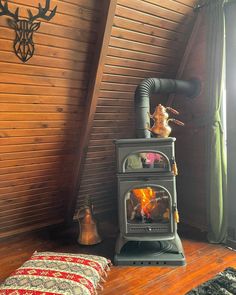 a wood burning stove sitting in the corner of a room next to a window with curtains