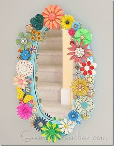 a mirror that has flowers on it in the shape of a flower and leaves frame