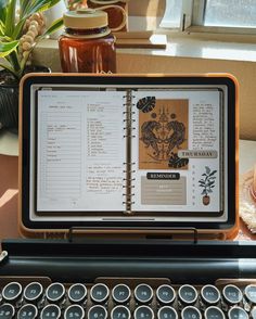 an open book sitting on top of a computer keyboard