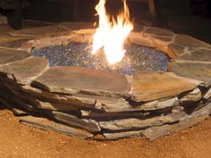 an outdoor fire pit with rocks around it